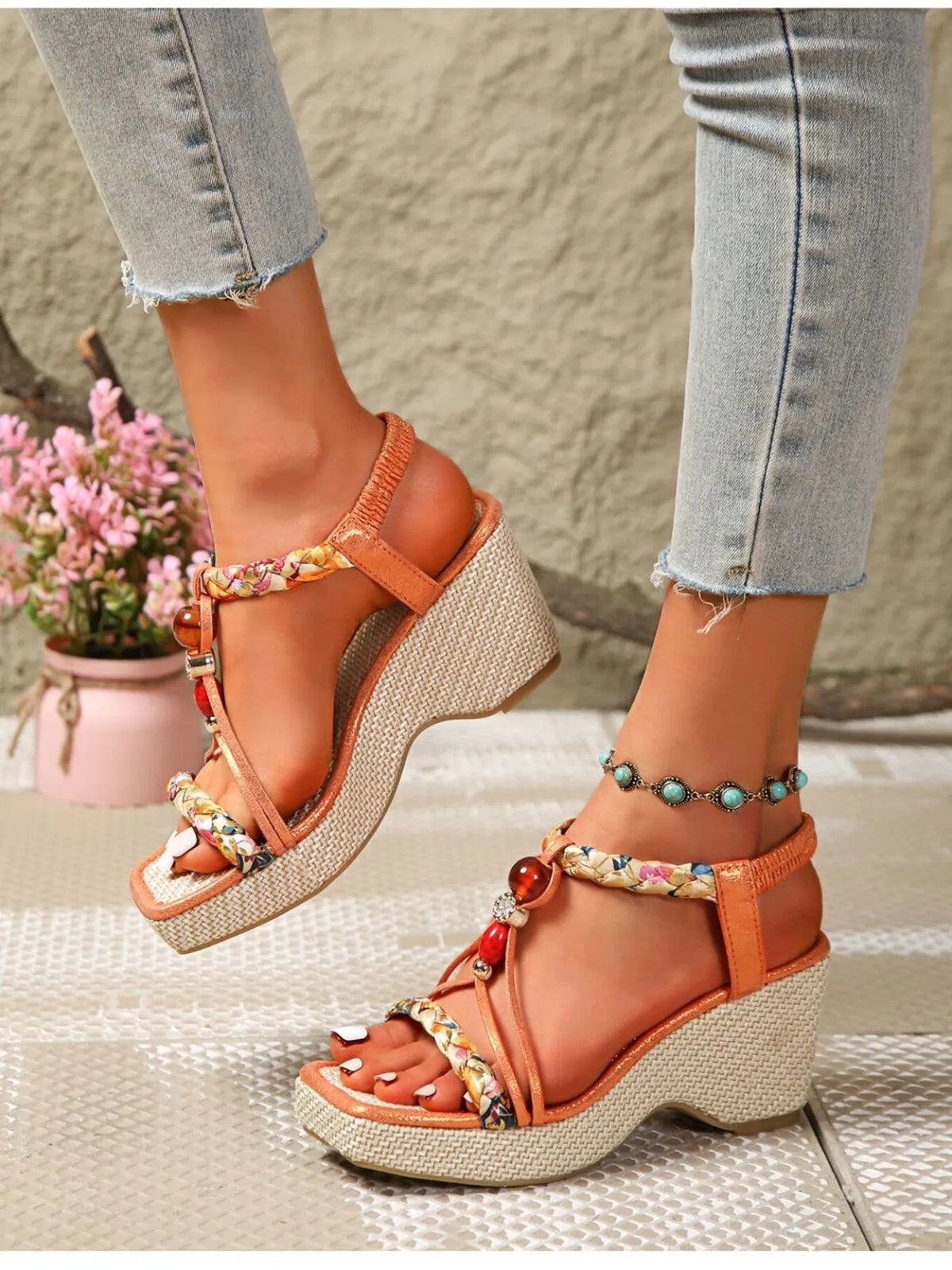 Wedge sandals with orange straps, beige wedge, colorful floral trim, and teal bead ankle