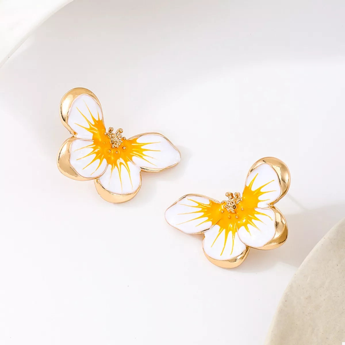 Orange butterfly stud earrings with white petals and gold-tone bezels