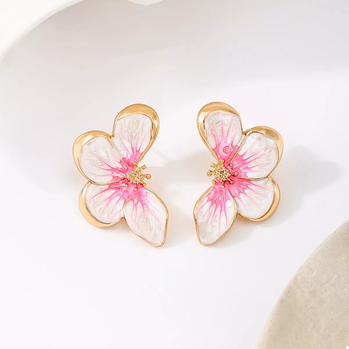Pink butterfly stud earrings with white petals, gold-tone flower, and sparkle center