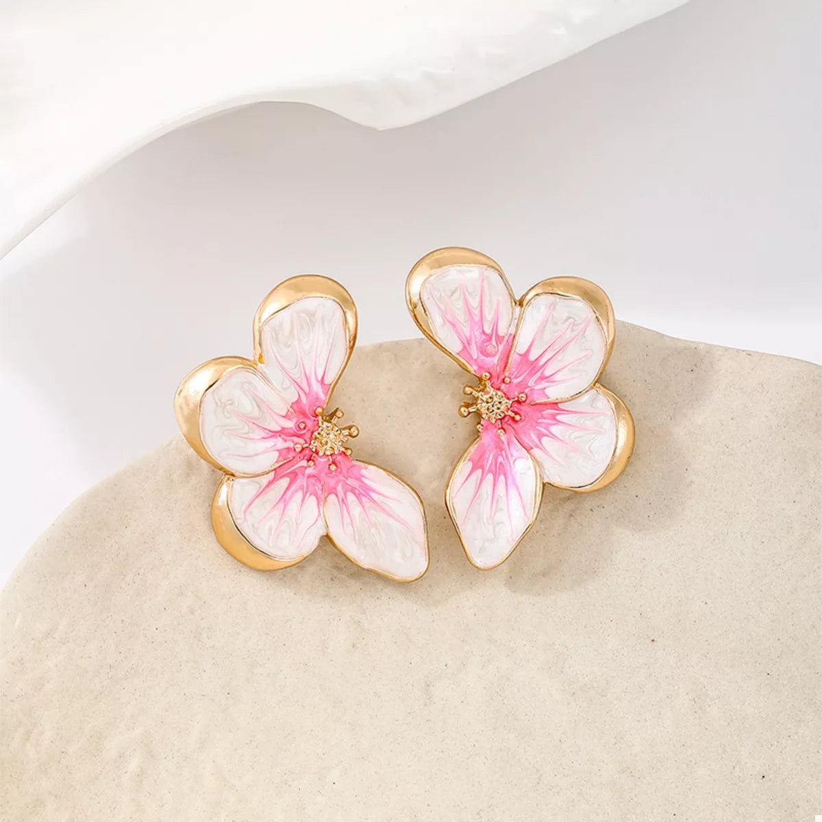 Pink butterfly stud earrings with white petals and gold-tone frames