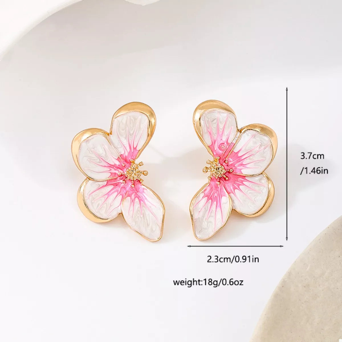 Pink butterfly stud earrings with white petals, gold-tone setting, and crystal center