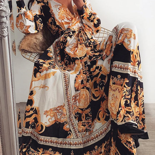Women’s long-sleeve maxi dress detail view: V-neck wrap and flowing skirt in baroque print.