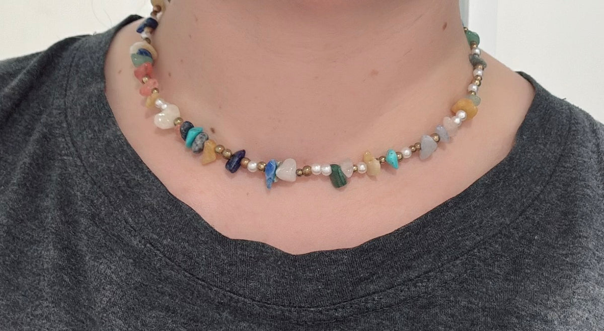 Multicolor crystal bead necklace choker worn on the neck with small blue and green accents.