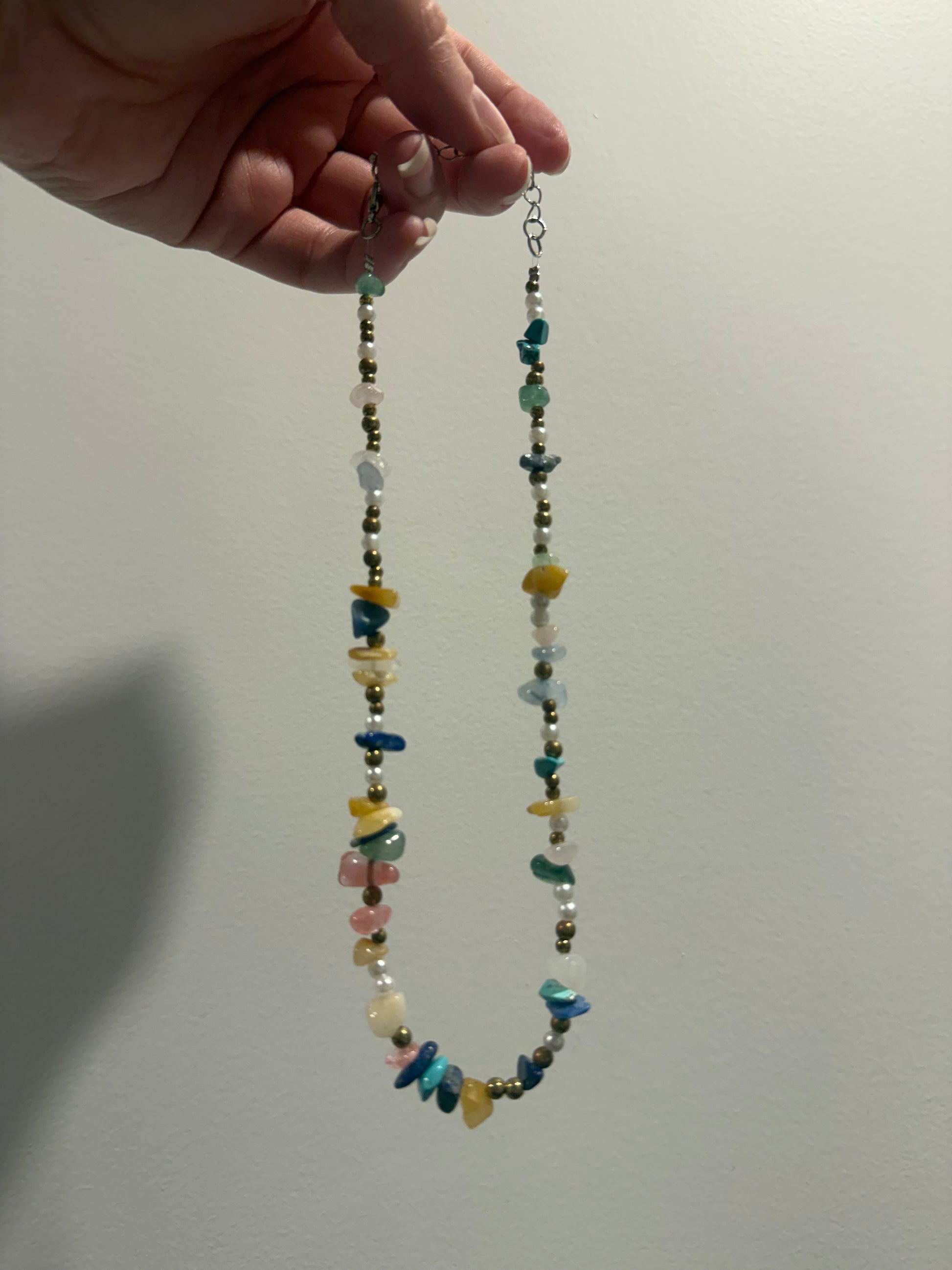 Long multicolor crystal bead necklace with white, green, blue, yellow, and pink stones.