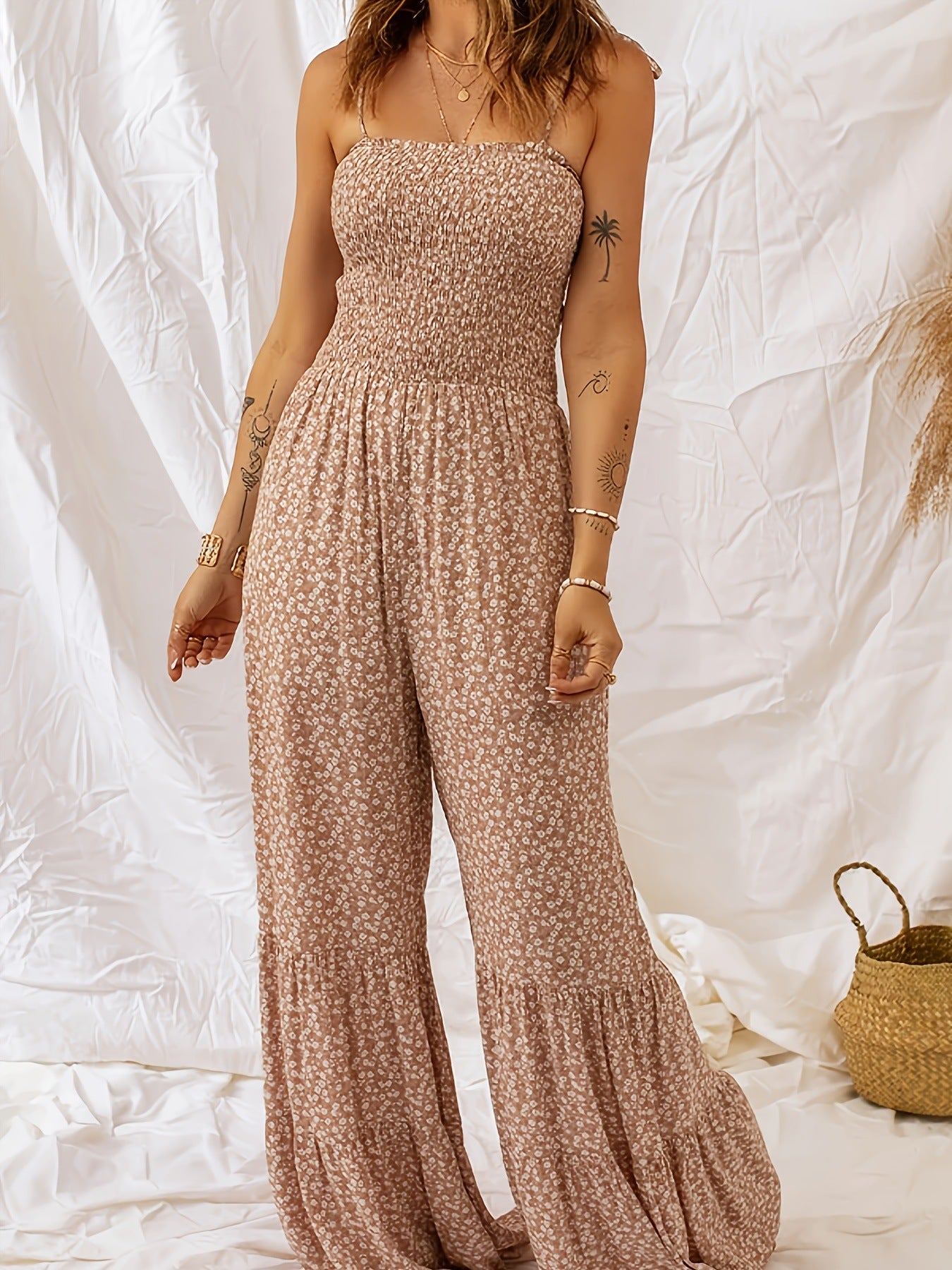 Light beige floral jumpsuit with square neckline, thin straps, and flared wide legs