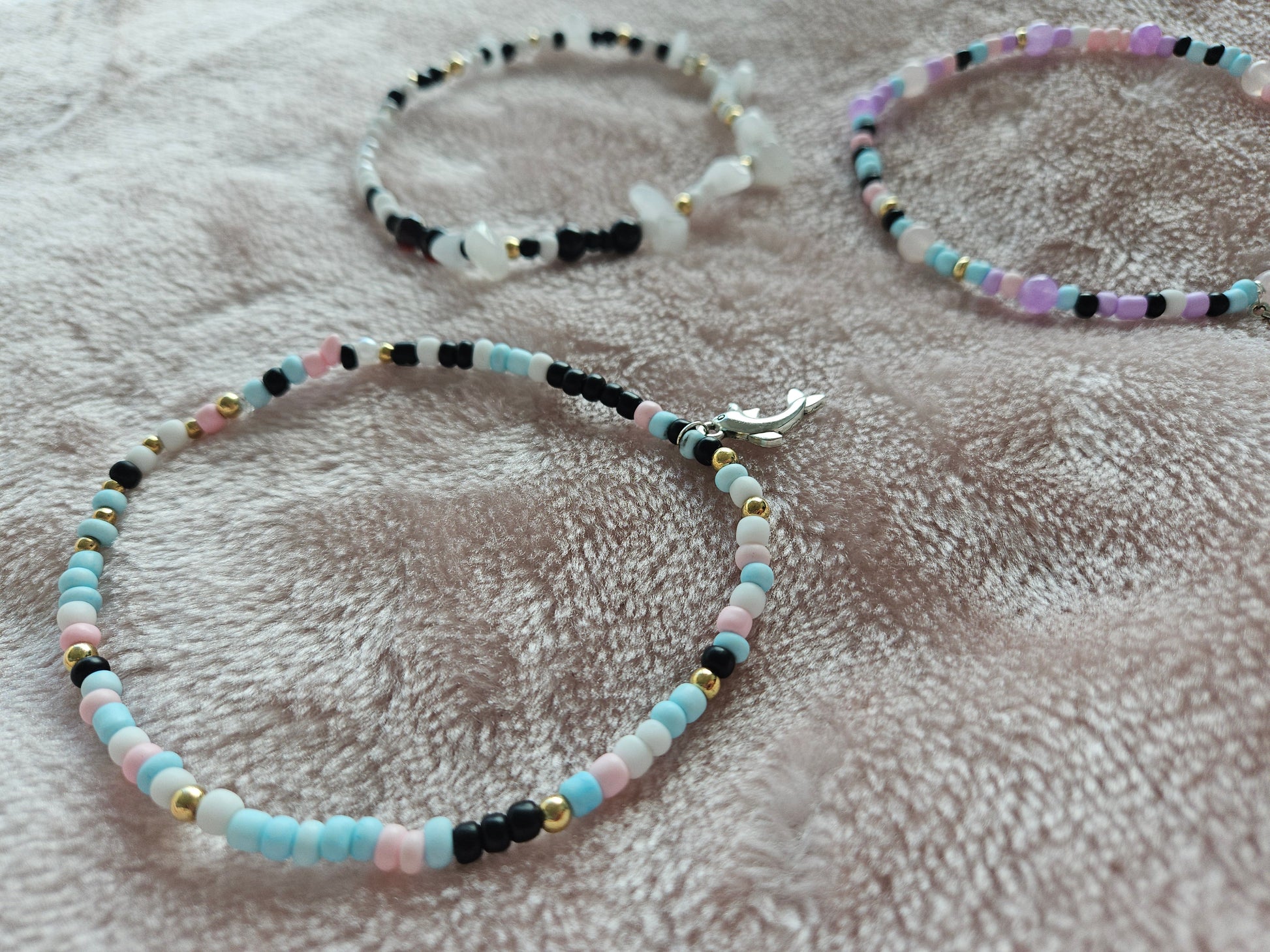 Three beaded bracelets on a textured surface