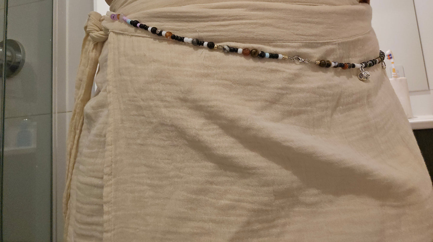 Beige skirt with a beaded belt in a bathroom setting
