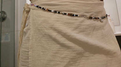 Beige skirt with a beaded belt in a bathroom setting