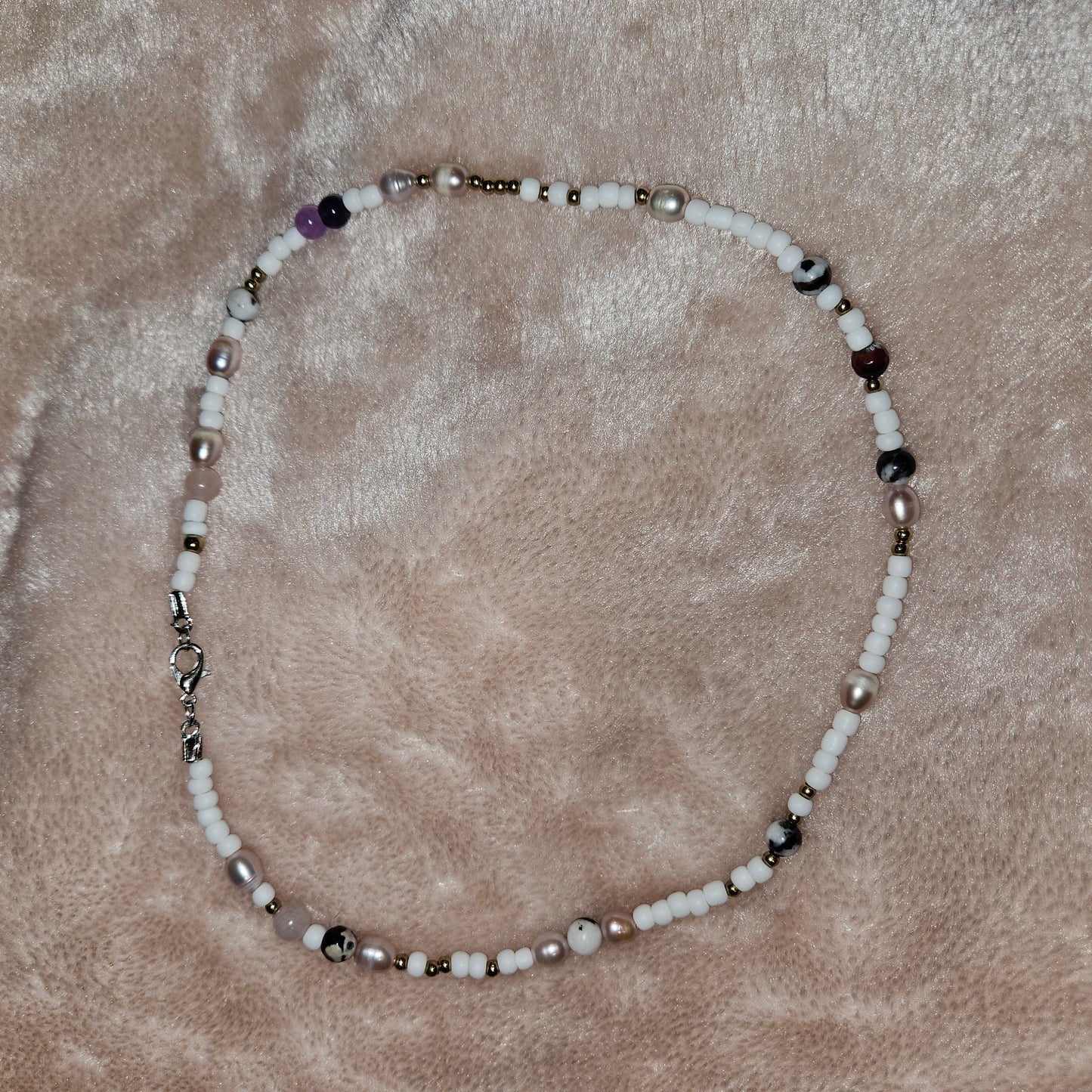 Beaded necklace on a textured beige surface