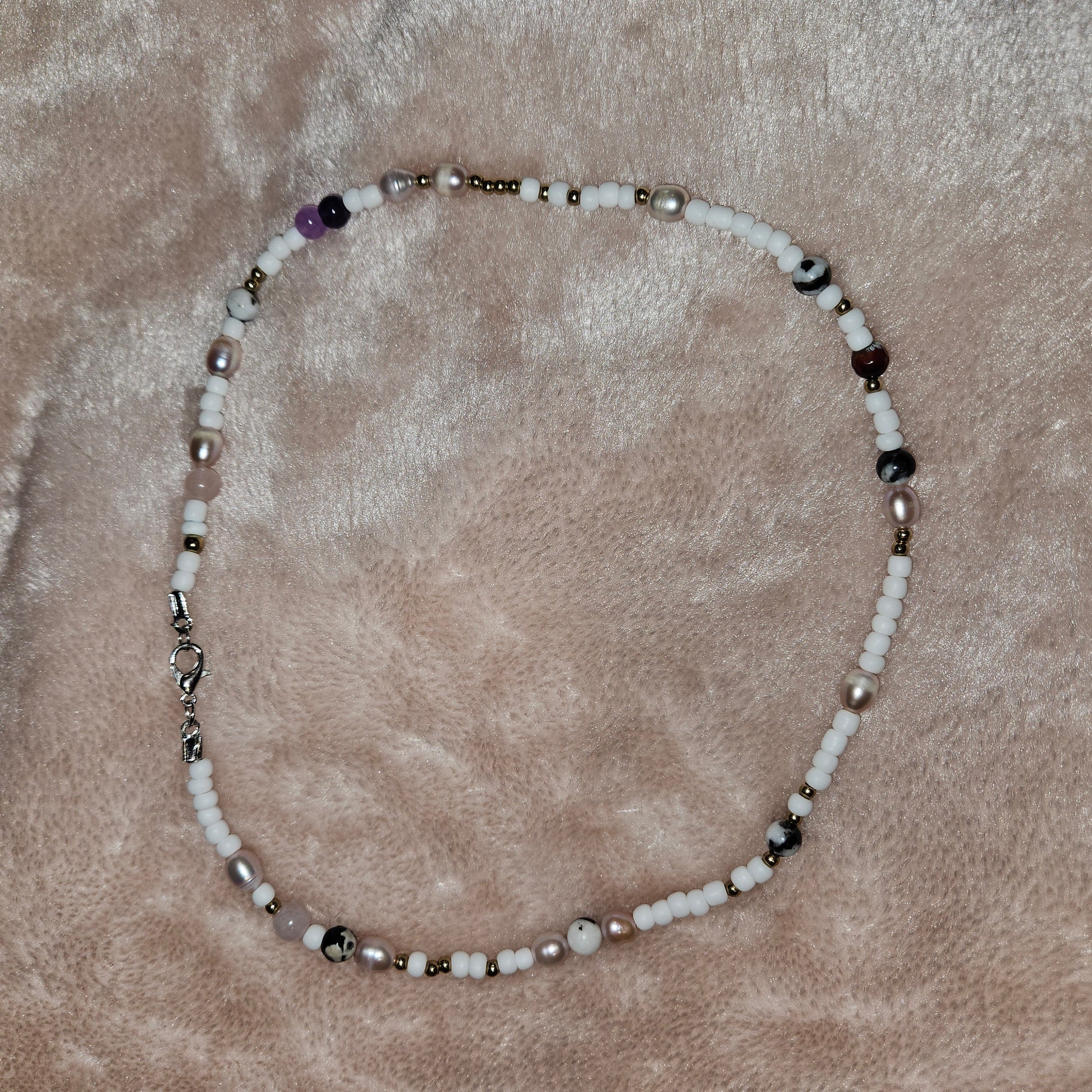 Beaded necklace on a textured beige surface