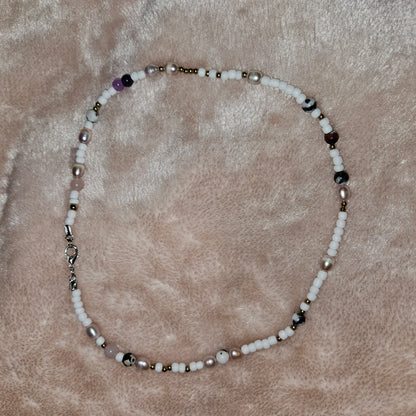Beaded necklace on a textured beige surface
